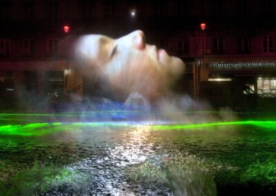 Éclairage festif à Lyon lors de la Fête des Lumières: projection d'un visage en hologramme au-dessus de l'eau