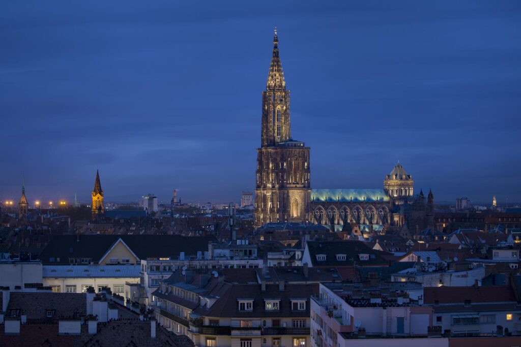 Cathédrale de Strasbourg éclairée de nuit: plan large au-dessus des toits