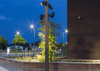 Mât en bois Aubrilam éclairant le parking de supermarché à Rennes, intégration paysagère et éclairage uniforme, nuit