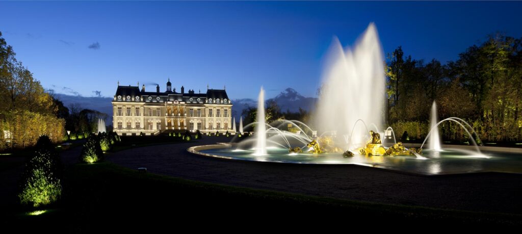 Mise en valeur du château de Louveciennes avec une grande fontaine éclairée au premier plan