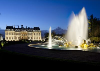 Mise en valeur du château de Louveciennes avec une grande fontaine éclairée au premier plan