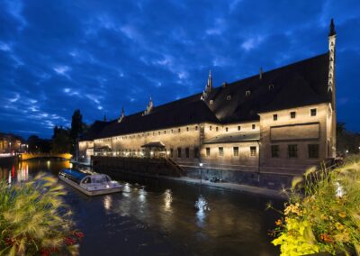 Mise en valeur des anciennes douanes de Strasbourg avec l'Ill au premier plan, photographie prise à l'heure bleue