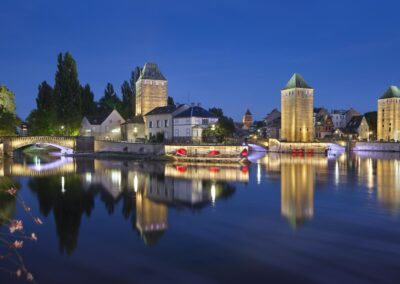 Mise en valeur des ponts couverts de Strasbourg à l'heure bleue se reflétant dans l'eau de l'Ill