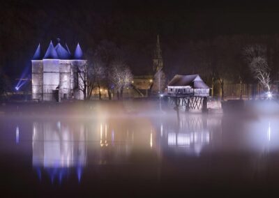Mise en lumière des Tourelles et du Vieux Moulin de Vernon se reflétant dans la Seine. Brume