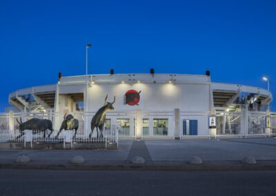 Façade des arènes du Grau-du-Roi (Gard) éclairée de nuit, sculptures de taureaux.