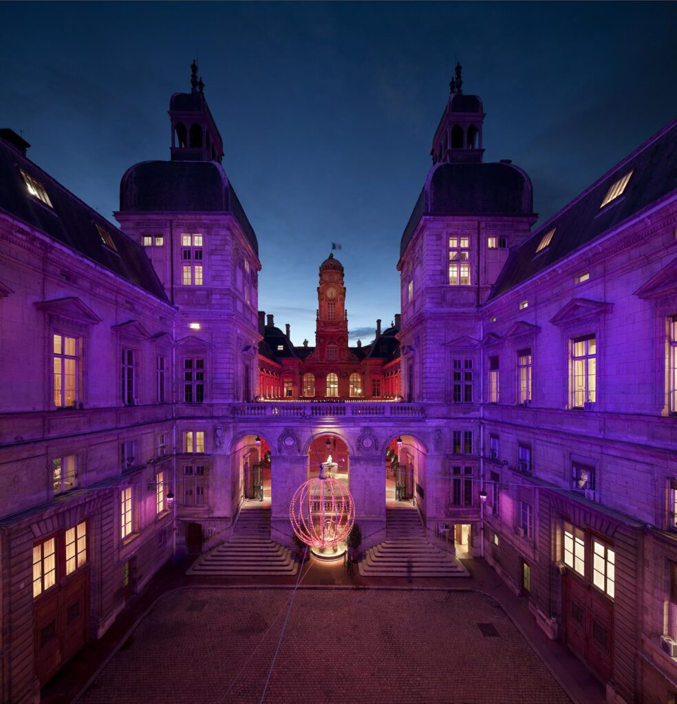 Cour de l'hôtel de ville de Lyon mis en valeur par un éclairage magenta lors de la fête des lumières