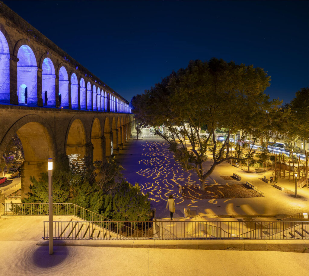Place Max Rouquette à Montpellier de nuit: le viaduc, les marches, des dessins de lumière au sol