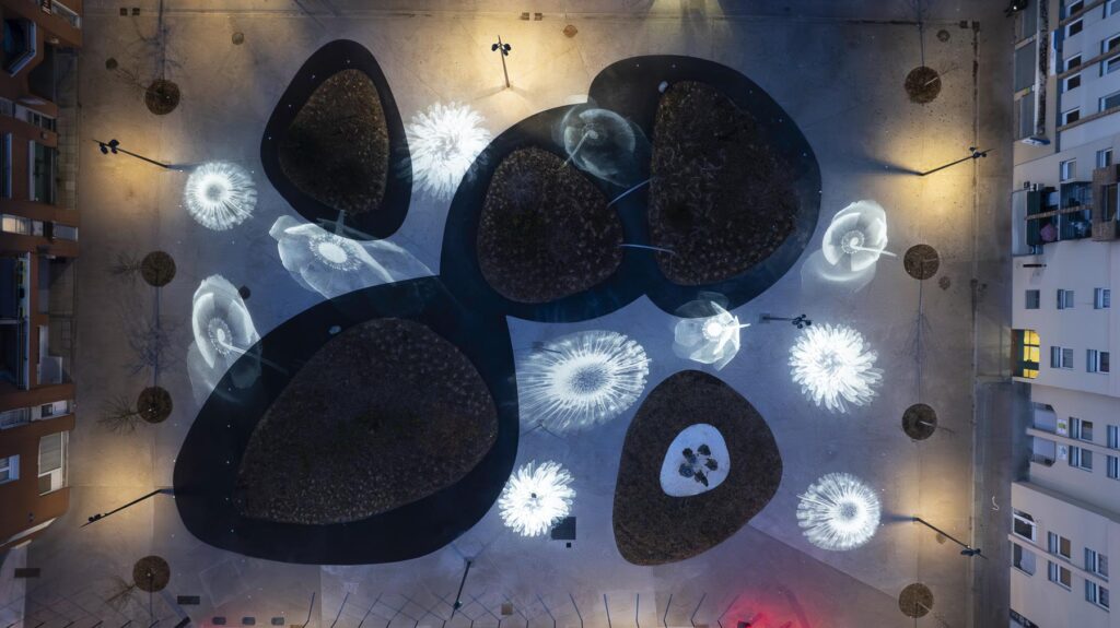 Vue aérienne par drone de la place du Commerce à Plaisir: éclairage gobo dessinant comme des fleurs ou des méduses